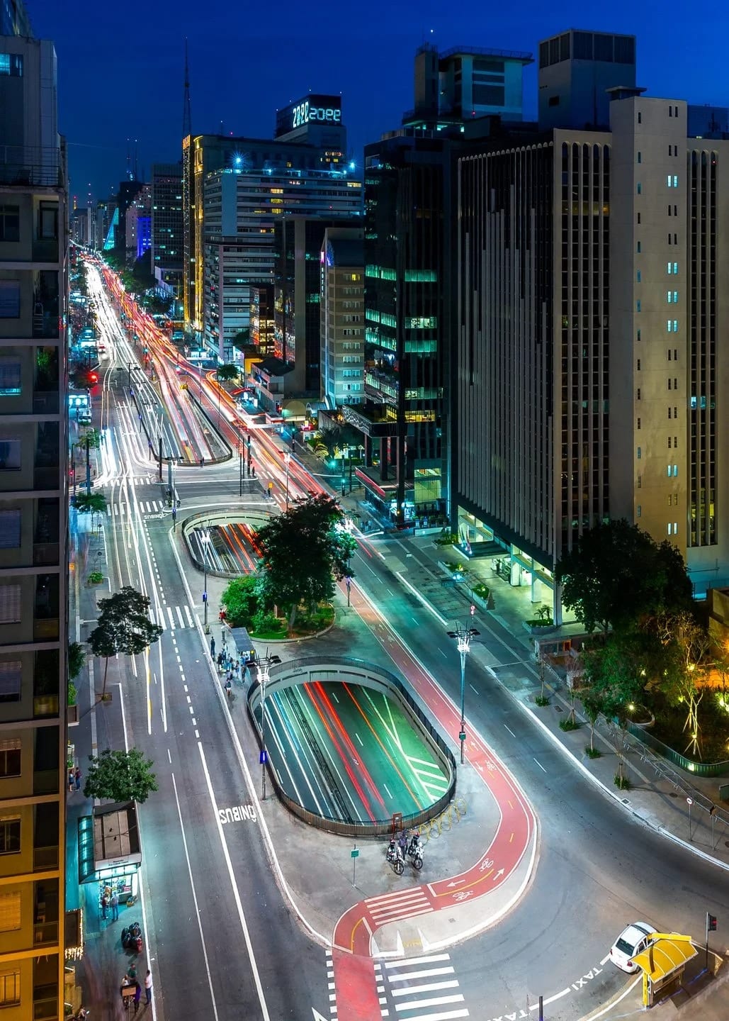 Circuito Paulista, fotografia fine art de Bruno Boni. A Paulista em plena hora azul. As aberturas ovais no canteiro central interrompem a rigidez da avenida e dão ritmo à…
