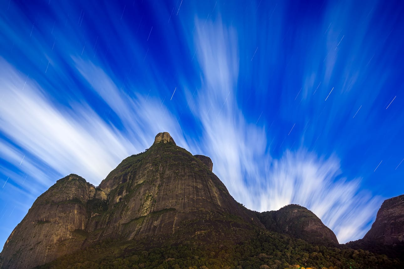Pedra da Gávea 480, fotografia fine art de Bruno Boni. Exposição noturna de 8 min (480 s) sobre a Pedra da Gávea: nuvens velozes parecem pinceladas, estrelas deixam trilhas…